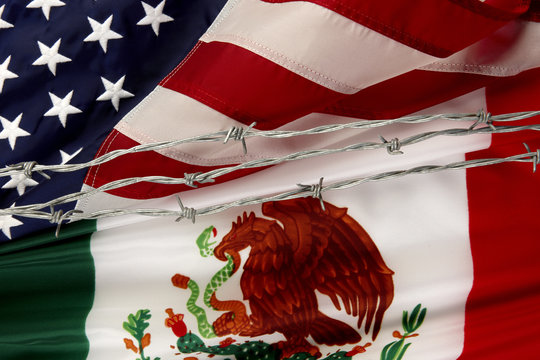 US and Mexican flags separated by barbed wire