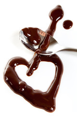 Melted dark chocolate on plate and steel spoon. Heart shape