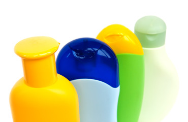 four colured shampoo bottles isolated on white