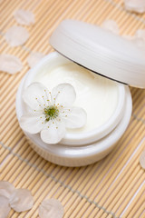 Obraz na płótnie Canvas cosmetic moisturizing cream with flower