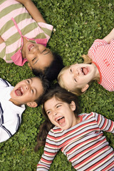 Children Lying in Clover Screaming With Heads Together