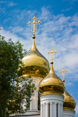 Fototapeta na wymiar The three golden domes and crosses Orthodox monastery in Russia