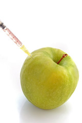 Green apple with a syringe on a white background