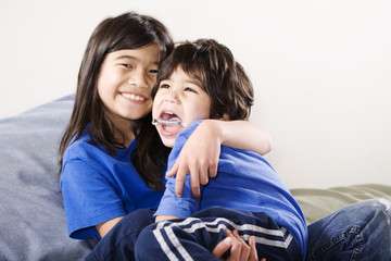 Big sister holding her disabled little brother