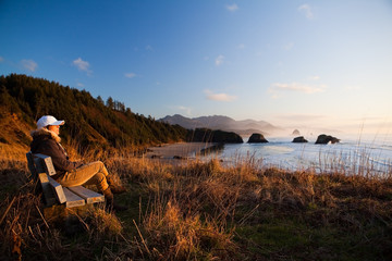 woman on bench overlooking coast