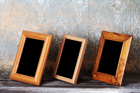 three photo-frames on old table