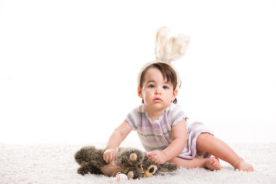 Baby girl playing with toy rabbit