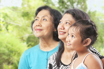 Three Asian female generations looking away