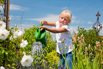 Little girl watering flowers