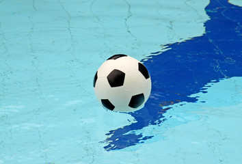 Fototapeta na wymiar Ball in blue pool water to background