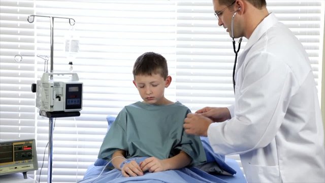 A Pediatrician examining a coughing hospitalized child.