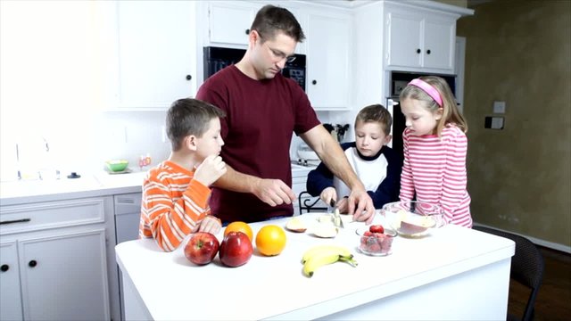 Dolly left dad and kids cutting and eating fruit