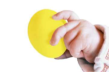 Die Babyhand hält ein gelbes Ei fest, Osterei, Ostern