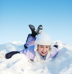 Fototapeta na wymiar Little girl sliding in the snow