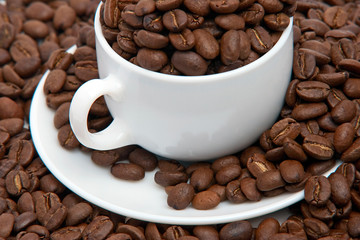 Cup with a saucer and coffee grains