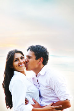 Happy young people hugging and kissing portrait at the beach