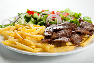 Grilled meat with fried potatoes and vegetables