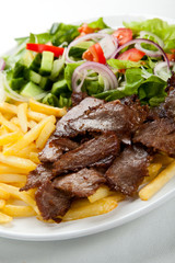 Grilled meat with fried potatoes and vegetables