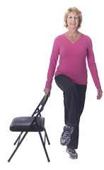 Senior woman practising balance with chair
