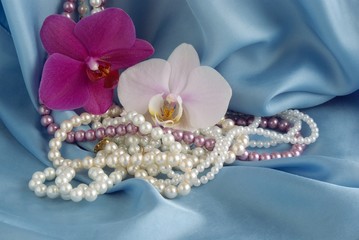 jewelery and flowers on blue silk background