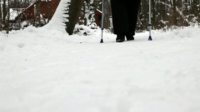 Senior mit Kr&uuml;cken nach Knieoperation, beim Winterspaziergang