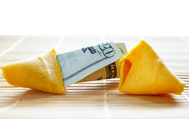 broken open fortune cookie with money inside