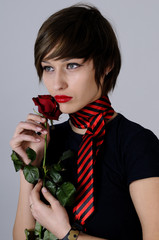 young woman smelling red rose