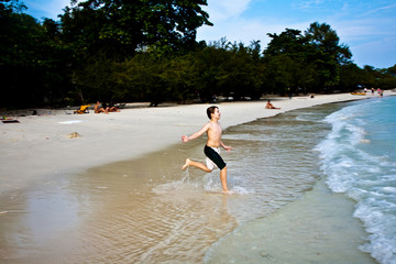 Fototapeta premium young happy boy with brown hair enjoys the beach