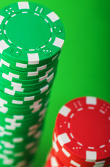 Casino chips and cards against green background