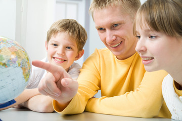 Happy family examining a globe