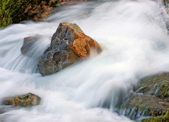 Stone in waterfall stream