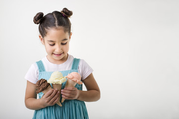 little girl holding three ice cream cones