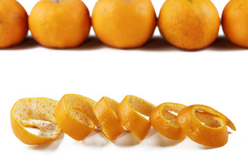 Orange peel with some mandarin oranges in the background