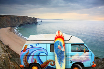 Van and surf board at a beach