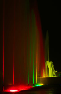 Different colorful lit fountains shot at night