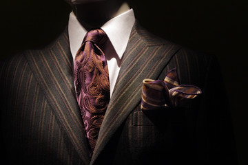 Dark brown striped jacket, purple tie and handkerchief.