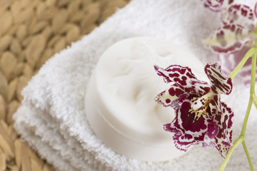 Spa items with white towels, natural soap and orchid