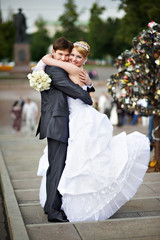 Happy bride and groom at wedding walk on Luzhkov bridge