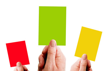 Hands holding red, yellow and green cards