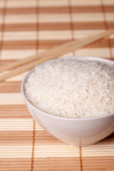 white rice in bowl and chopsticks