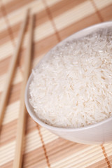 white rice in bowl and chopsticks