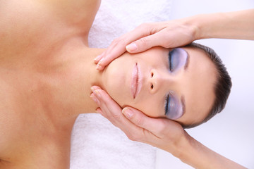 Obraz na płótnie Canvas Beautiful young woman receiving facial massage.
