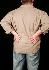 male with back pain on black background
