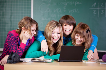 schüler sitzen zusammen vor einem laptop