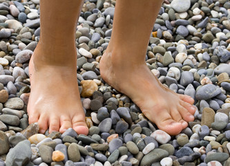 Childish legs on pebble