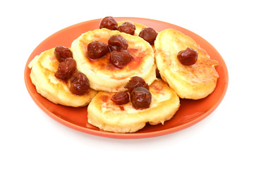 pancakes with cherry jam on the red plate isolated on white