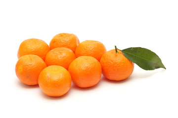 alone mandarine with leaf in the crowd of leafless mandarines