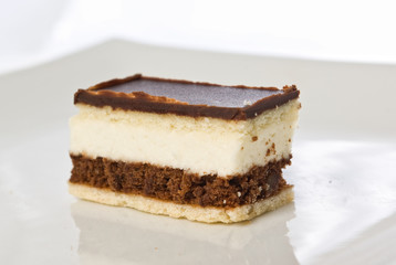 piece of a chocolate cake with white cream on a plate