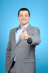 Handsome businessman thumb up on blue background