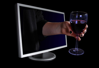 Hand offering a glass of wine through a computer monitor